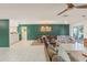 Open living room with tiled floors, green accent wall and dining set under an ornate chandelier at 5237 Gateway Ave, Orlando, FL 32821