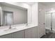 Bright bathroom featuring a double vanity, large mirror, and glass-enclosed shower at 667 Bay Leaf Dr, Kissimmee, FL 34759