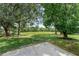 Spacious backyard with mature trees, large grassy area, and a new concrete patio at 762 Lake Como Dr, Lake Mary, FL 32746
