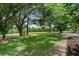 Beautiful backyard with expansive lawn, shade trees, and views of a grassy field at 762 Lake Como Dr, Lake Mary, FL 32746