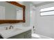 Bathroom with vanity, decorative framed mirror, and shower-tub combo with tiled walls at 762 Lake Como Dr, Lake Mary, FL 32746