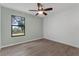 Bedroom with a large window offering views, hardwood floors, and a ceiling fan at 762 Lake Como Dr, Lake Mary, FL 32746