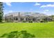 Expansive backyard with lush green lawn and screened-in pool area, perfect for outdoor entertaining at 856 Bentley Green Cir, Winter Springs, FL 32708