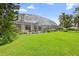 Expansive backyard with lush green lawn and screened-in pool area, offering privacy and space at 856 Bentley Green Cir, Winter Springs, FL 32708