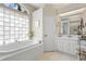 Bright bathroom featuring a large tub, white cabinetry, and glass block window for natural light at 856 Bentley Green Cir, Winter Springs, FL 32708