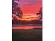 Picturesque view of a golf course with a serene lake and a vibrant, colorful sunset backdrop at 856 Bentley Green Cir, Winter Springs, FL 32708