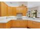 Kitchen features light wood cabinetry, tile countertops and backsplash with undercabinet lighting at 856 Bentley Green Cir, Winter Springs, FL 32708