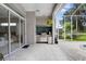 An outdoor kitchen in the screened patio with tiled backsplash, grill, and mini fridge for outdoor cooking at 856 Bentley Green Cir, Winter Springs, FL 32708