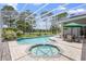 A screened-in pool and hot tub, surrounded by brick pavers with view of the golf course in the background at 856 Bentley Green Cir, Winter Springs, FL 32708