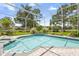 Clear swimming pool and hot tub with a screened enclosure, surrounded by lush landscaping and green lawn at 856 Bentley Green Cir, Winter Springs, FL 32708