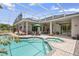 Backyard pool and spa surrounded by a screened enclosure with views of the home and outdoor seating areas at 856 Bentley Green Cir, Winter Springs, FL 32708