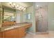 Bathroom featuring granite counters, light fixtures, walk-in shower, and green walls at 9128 Phillips Grove Ter, Orlando, FL 32836