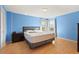 Bright bedroom with wood floors, blue walls, and double windows allowing natural light at 9128 Phillips Grove Ter, Orlando, FL 32836