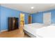 Bright bedroom with wood floors, blue walls, and a bed with a gray frame at 9128 Phillips Grove Ter, Orlando, FL 32836
