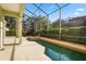 A backyard pool surrounded by a screen enclosure and lush landscaping at 9128 Phillips Grove Ter, Orlando, FL 32836
