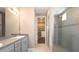 Well-lit bathroom with granite countertops, a glass-enclosed shower, and access to a walk-in closet at 922 Suffolk Pl, Davenport, FL 33896