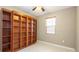 Bright bedroom featuring a large built-in wooden bookcase, ceiling fan, and a window with natural light at 922 Suffolk Pl, Davenport, FL 33896