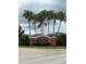 A community entrance sign is framed by palm trees under a cloudy sky at 922 Suffolk Pl, Davenport, FL 33896