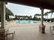 Community pool surrounded by lounge chairs and palm trees on a cloudy day at 922 Suffolk Pl, Davenport, FL 33896