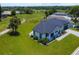 An aerial view of the home shows the roof, front yard, neutral exterior and beautiful landscaping at 1006 Linkside Ct, Apopka, FL 32712