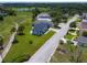 A home in a community with a large greenbelt, palm trees, and a gray brick driveway and walkway at 1006 Linkside Ct, Apopka, FL 32712