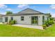 A backyard featuring a well-maintained lawn, patio, and modern siding with dark trim windows at 1006 Linkside Ct, Apopka, FL 32712