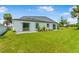 Rear exterior view showing a lush backyard, well-maintained lawn and neutral colored exterior at 1006 Linkside Ct, Apopka, FL 32712