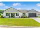 Charming single-story home with a well-manicured lawn, dark shutters, and an attached two-car garage at 1006 Linkside Ct, Apopka, FL 32712