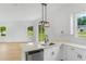 Bright kitchen featuring white cabinets, stainless steel appliances, and a modern pendant light fixture at 1006 Linkside Ct, Apopka, FL 32712
