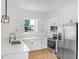 Well-lit kitchen featuring white cabinets, stainless steel appliances, and modern fixtures at 1006 Linkside Ct, Apopka, FL 32712
