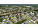 An aerial view displaying the home within the surrounding neighborhood and lush green trees at 10299 Cypress Knee Cir, Orlando, FL 32825
