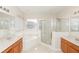 Bathroom featuring double vanity, separate shower, and soaking tub at 10299 Cypress Knee Cir, Orlando, FL 32825