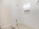 Bathroom featuring a shower/tub combo with tile surround and a small window at 10299 Cypress Knee Cir, Orlando, FL 32825