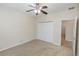 Neutral bedroom featuring a ceiling fan, carpet, and a closet with double doors at 10299 Cypress Knee Cir, Orlando, FL 32825
