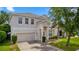 Two-story home featuring an attached garage, well-maintained landscaping, and neutral exterior paint at 10299 Cypress Knee Cir, Orlando, FL 32825