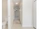 Hallway with neutral colors, light tile floor and access to a bathroom on the left at 10299 Cypress Knee Cir, Orlando, FL 32825