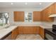 Functional kitchen featuring wood cabinetry, white counter tops, tile floors, and a window for natural light at 10299 Cypress Knee Cir, Orlando, FL 32825