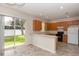 Eat-in kitchen featuring oak cabinetry, black appliances, a breakfast bar, and a sliding glass door to the backyard at 10299 Cypress Knee Cir, Orlando, FL 32825