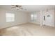 Spacious living room with neutral carpet, ceiling fan, and two windows for plenty of natural light at 10299 Cypress Knee Cir, Orlando, FL 32825