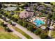 Aerial view of a community clubhouse and resort-style pool, tennis courts and parking at 1097 Harmony Ln, Clermont, FL 34711