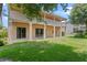 Spacious backyard patio with sliding glass doors and large columns leading to a second-story balcony at 1097 Harmony Ln, Clermont, FL 34711