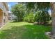 A spacious backyard features lush green grass and is framed by mature trees and manicured landscaping at 1097 Harmony Ln, Clermont, FL 34711