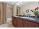 Bathroom featuring a double vanity, large mirror, tiled shower, and soaking tub at 1097 Harmony Ln, Clermont, FL 34711