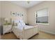Cozy bedroom with a queen bed, plush carpet, bright window, and a coastal-themed decor at 1097 Harmony Ln, Clermont, FL 34711