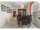 Sophisticated dining room with a wooden table, hutch, chandelier, and arched entryway leading to the kitchen at 1097 Harmony Ln, Clermont, FL 34711
