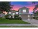 Elegant two-story home boasts a manicured lawn, mature landscaping, and a three-car garage, perfect for Gathering living at 1097 Harmony Ln, Clermont, FL 34711