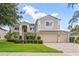 Charming two-story home with manicured landscaping, three-car garage, and a welcoming facade exuding suburban elegance at 1097 Harmony Ln, Clermont, FL 34711