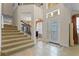 Spacious foyer featuring tile flooring, a staircase, and a front door with sidelights, creating a grand entrance at 1097 Harmony Ln, Clermont, FL 34711