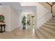 Inviting foyer with tile flooring, a staircase, and an arched entryway leading to a room with a fireplace at 1097 Harmony Ln, Clermont, FL 34711