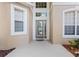 Close-up of the front door with sidelights and transom window, set in an alcove, and surrounded by large windows at 1097 Harmony Ln, Clermont, FL 34711